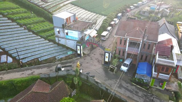Aerial view of the entrance gate from the village of Butuh, Nepal Van Java with golden statue of Mountain climber. Famous tourist village on the slope of Mount Sumbing, Central Java, Indonesia