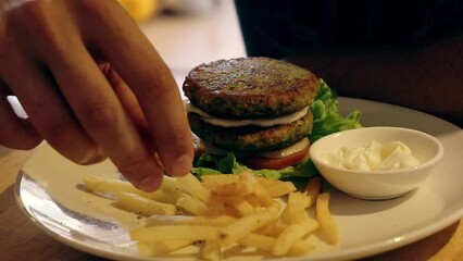 Eating fries and vegan falafel burger, a healthy sustainable clean diet