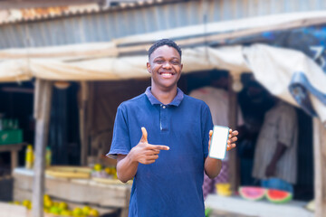 young black man using his mobile phone in a typical local africa market