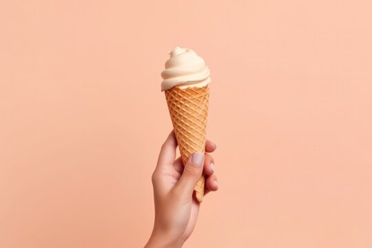 Woman's hand holding an ice cream cone on a pink background. Generative AI