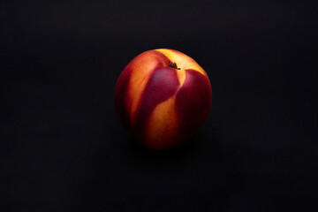 Ripe nectarine on black background