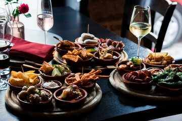 Tapas Bowls with Food arranged on a Table in a Tapas Bar. - obrazy, fototapety, plakaty