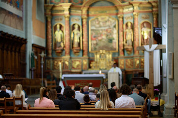 Cérémonie religieuse dans une église derrière les personnes - obrazy, fototapety, plakaty