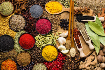 Colorful spices and herbs background. Large set seasonings scattered on table.