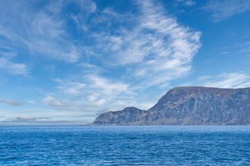 Fototapeta na wymiar View from the sea to the West Cape in Norway in sunshine with light clouds