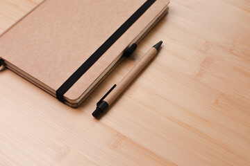 Signature template. Natural notebook with a pen made of eco materials on a wooden, bamboo background. Top view. Copy space