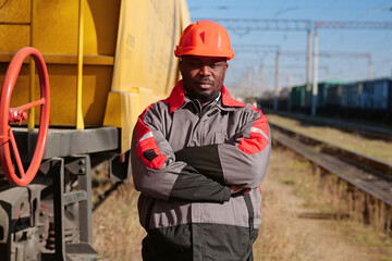 Railroad man in uniform and red hard hat look at the camera