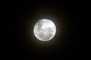 Naklejka na ściany i meble The Full Moon rising amongst the high cloud in the cold night air sky