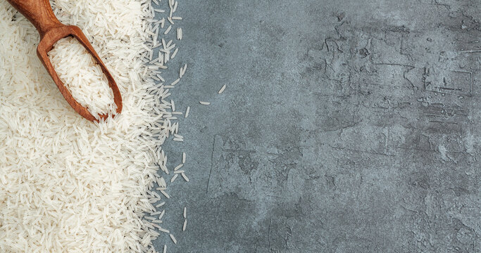 Raw white rice and wooden spoon