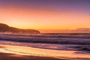 Fototapeta na wymiar Sunrise and Waves - Surf's up at the seaside