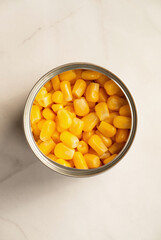 Canned sweet corn in opened tin can, top view.