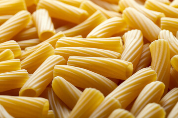 Uncooked authentic italian rigatoni pasta background, close-up.