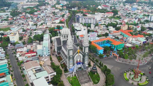 Aerial view of Thu Dau Mot cityscape at morning with church on hill in center. Urban development texture, transport infrastructure and green parks along Be River in Southeast region of Vietnam
