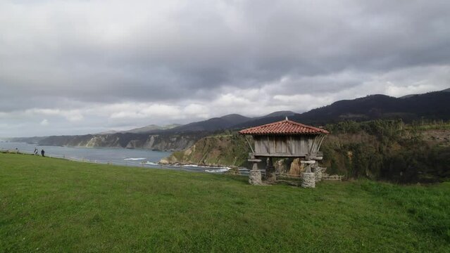 Aerial shot of a horreo, traditional granary from the north of Spain in a cliff next to the sea in the village of Cadavedo. Asturias