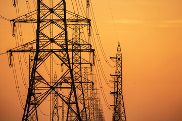 High voltage electric transmission tower. High voltage power lines on electric pylon against a sunset sky. Electrical infrastructure. Energy crisis. Electric power distribution. Energy distribution.