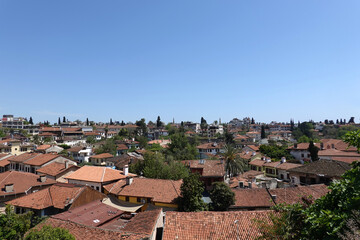 Fototapeta na wymiar Panoramic view of the tiled roofs of dense standing houses of the Antalya old city from the observation deck on a sunny day