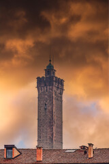 Naklejka premium Bologna, Italy Asinelli Tower, part of Due Torri, medieval Two Towers city symbol, against dramatic orange clouds.