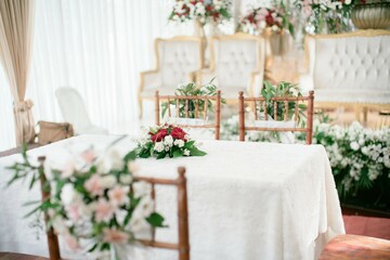 A luxurious Indonesian-style wedding altar with a grand table and chairs, adorned with intricate carvings and gold accents, fit for a royal wedding