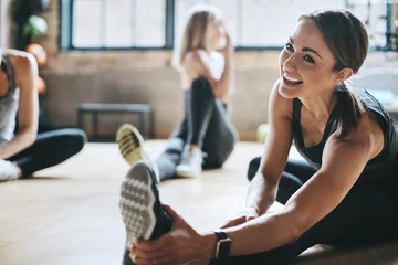 Photo sur Plexiglas Fitness Fitness, gym and women stretching, exercise and workout goal for wellness, balance and stress relief. Female people, girls and athletes on the floor, stretch legs and smile with training and health