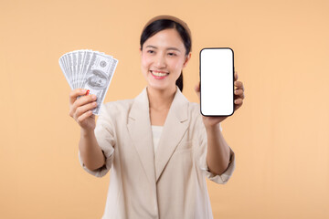 portrait of happy successful confident young asian business woman wearing white jacket holding smartphone and cash money dollar standing over beige background. millionaire business, shopping concept.