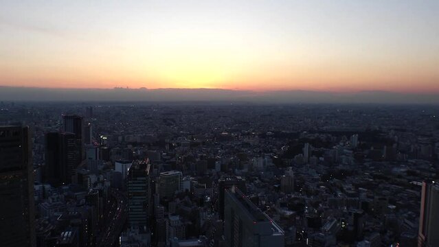 TOKYO, JAPAN : Aerial high angle sunrise CITYSCAPE of TOKYO. View of rising sun and dramatic sky around Shibuya. Japanese urban city life and nature concept video. Time lapse shot, night to morning.