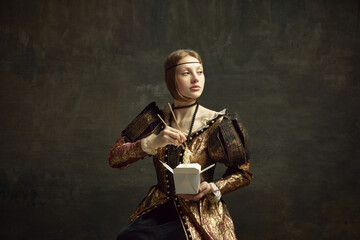 Portrait of young girl, royal person, princess in vintage dress eating noodles with chopsticks on dark green background. Concept of history, renaissance art remake, comparison of eras, food, delivery