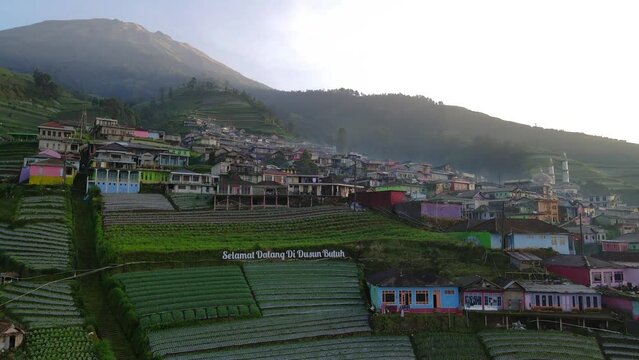 Aerial view : Morning at Nepal Van Java. Slightly fog shrouded the house of village. text "Selamat Datang di Dusun Butuh" or "Welcome to Butuh Village" installed at the entrance of Nepal Van Java