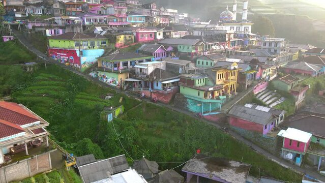 Drone shot : motorcycle crossing uphill road in the middle of Nepal Van Java village. Motorists deliver climbers to the Mount Sumbing climbing post - 4K aerial view