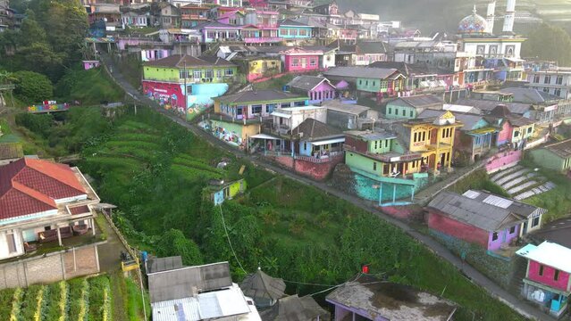 Aerial view : Beautiful colorful house of village on the slope of mountain. Butuh Village or Nepal Van Java on the slope of Sumbing Mountain, Indonesia - 4K drone video