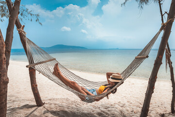 Traveler asian woman relax and travel in hammock on summer beach at Koh Rap Samui in Surat Thani Thailand