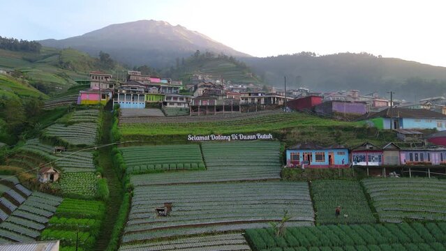 DRONE SHOT : Entrace of Nepal Van Java Village with text "Selamat Datang di Dusun Butuh" or "Welcome to Butuh Village". Morning view of Nepal Van Java - 4K aerial view