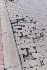 Fototapeta premium damaged and broken concrete tile road, close-up