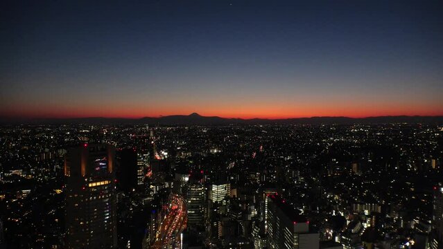 TOKYO, JAPAN : Aerial high angle sunset or sunrise view of CITYSCAPE of TOKYO and MOUNT FUJI. View of buildings and street around Shibuya. Japanese city life and nature concept 4K video.