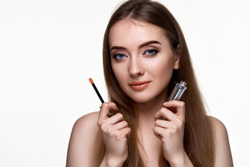 Fototapeta premium beautiful young woman testing nude lip gloss