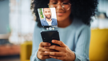 Augmented Reality Dating Concept: Awesome Black Girl Uses Smartphone for Browsing Social Media Dating App. Lovely Young Brazilian Woman Searching for True Love with the Help of AI Powered Software - obrazy, fototapety, plakaty