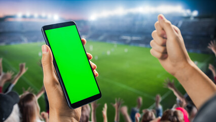 International Soccer Football Championship on Stadium: Fan on Tribune Holding Smartphone With Green Screen Chromakey Display, Cheering for Favourite Team. Isolated POV Close-Up Copyspace Template