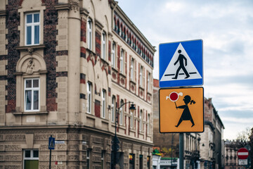 Road signs for children and pedestrians in old town of Krakow Poland against cloudy sky