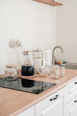 details of modern white kitchen furniture with teapots and cups on a countertop. clean country style kitchen. vertical shot. 