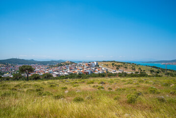 Fototapeta na wymiar A Turkish small town overlooking the sea and a green field on a summer and sunny day.