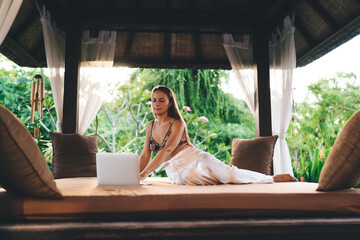 Young woman using netbook in exotic resort