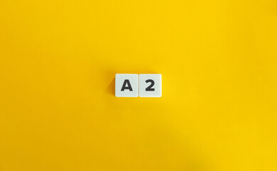 A2 level of language proficiency. Block Letter Tiles on Yellow Background. Minimal Aesthetics.