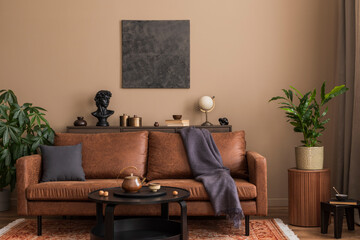 Warm and cozy living room interior with mock up poster frame, brown sofa, black coffee table, wooden sideboard, patterned rug, boucle armchair, pillows and personal accessories. Home decor. Template.