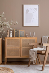 Cozy living room interior with mock up poster frame, rattan sideboard, wooden armchair, beige...