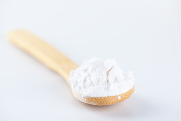White powdered tapioca starch in a wooden spoon, cassava root powder.