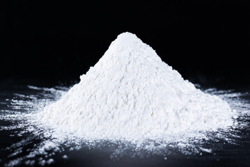 Heap of tapioca starch on a black background, dry cassava root.