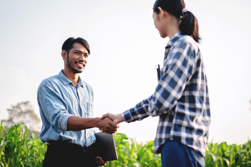 Two smart farmers shaking hands to celebrate after examining qua