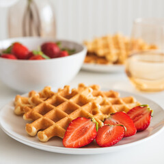 Belgian waffles with strawberry on white plate. Breakfast food concept