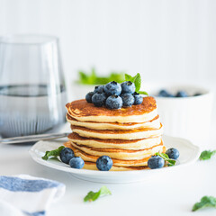 Homemade baked ricotta pancakes with fresh berries on white wooden table