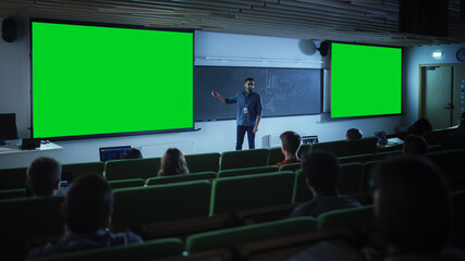 Young Male Teacher Giving a Lecture, Showing Slides on a Green Screen Mock Up Display to a Diverse...