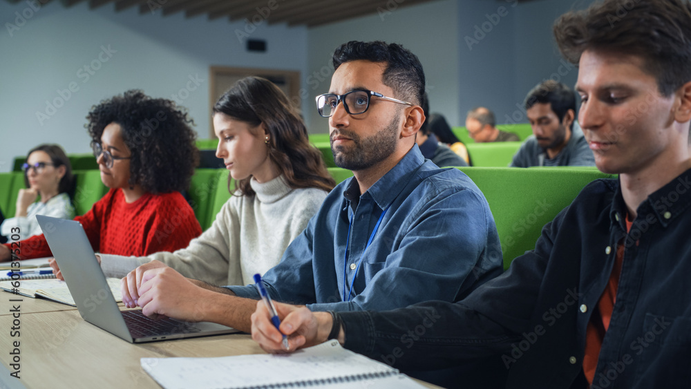 Aufkleber Smart Handsome Male Student Studying in University with Diverse Multiethnic Classmates. Young Man is Using a Laptop Computer to Summarize the Lecture, Study at Home and Pass the Exams